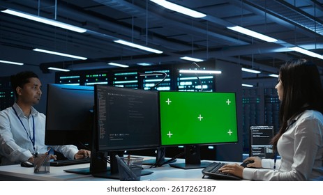 System administrator in data center installing software on green screen computer, troubleshooting issues. IT expert uses mockup PC in server hub, establishing performance benchmarks, camera B