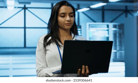 System administrator in data center monitoring security threats, implementing cybersecurity measures. Woman ensuring compliance with regulations to protect data center gear, camera A - Powered by Shutterstock