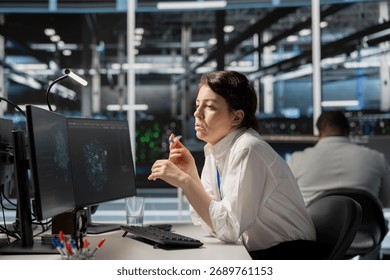System administrator in data center using AI powered tech to run simulations. Woman at work coding cognitive computing algorithms to extract insights from data and automate rigs