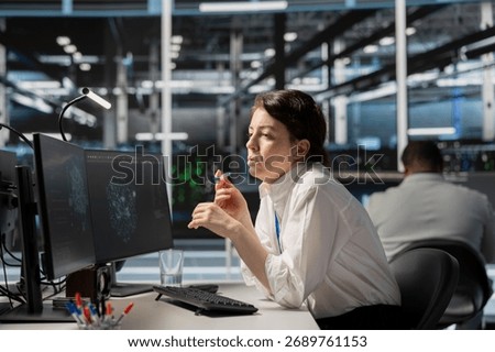 System administrator in data center using AI powered tech to run simulations. Woman at work coding cognitive computing algorithms to extract insights from data and automate rigs