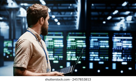 System administrator in server farm using renewable hydro energy sources to power blockchain mining operations. Specialist working with eco friendly supercomputers preventing environmental impact - Powered by Shutterstock