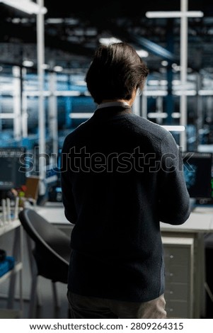 System administrator uses a computer in a data center to deploy software updates, configure hardware, and support reliable operations.