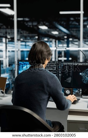 System administrator uses a digital device in a data center to support automation monitoring and reliable server workflows.