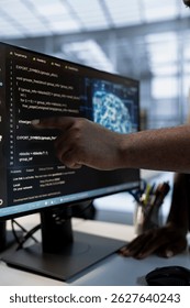 System administrator using machine learning applications to optimize server farm operations. IT expert pointing to PC monitor, implementing server virtualization in data center facility