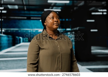 System administrator walking in data center with rigs supporting business needs. Woman in server hub doing checkup, ensuring infrastructure works at optimum performance for smooth operations