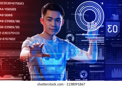 System control. Confident professional programmer smiling and touching the transparent screen while testing a new program of security control