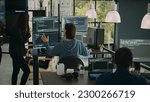 System engineer checking code on multiple monitors and working with app developer colleague in it agency office. Coder analyzing algorithm on screens, developing new user interface.