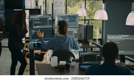 System engineer checking code on multiple monitors and working with app developer colleague in it agency office. Coder analyzing algorithm on screens, developing new user interface. - Powered by Shutterstock