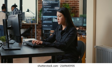 System engineer focused on writing code sitting at desk in software development office while team of coders are developing cloud computing app. Programer concentrating on creating algorithm.