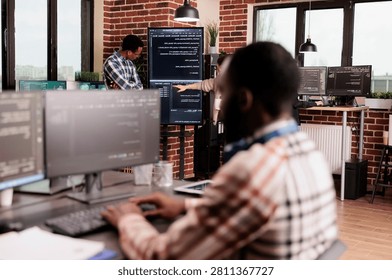 System engineers coding company network project presents a row-specific commercial moment, showing programming code, software teamwork and digital infrastructure in a modern software workspace.
