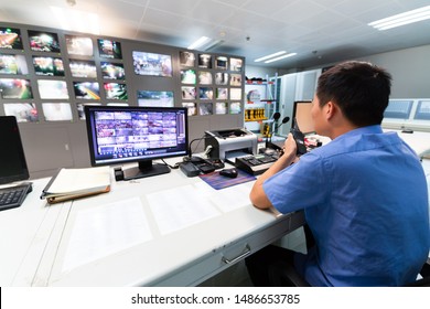 System Security Specialist Working at System Control Center. Room is Full of Screens Displaying Various Information. - Shutterstock ID 1486653785