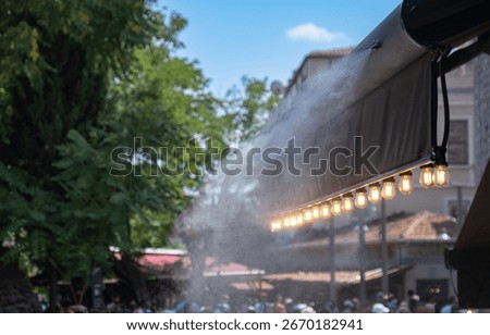 A system that cools the environment by spraying water in open-air cafe-type spaces.
