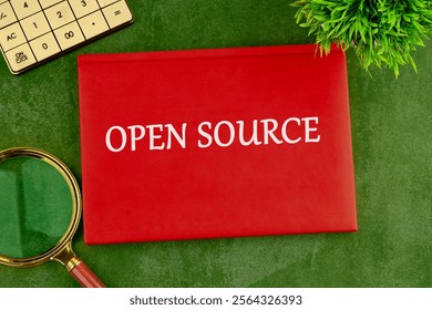 System and website builder concept. OPEN SOURCE on the cover of a red notebook on a green saturated background.