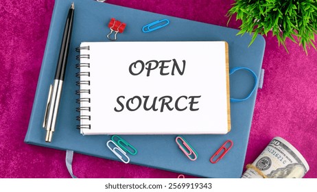 System and website builder concept. OPEN SOURCE in a mini notebook on a business book, top view. Copy space.
