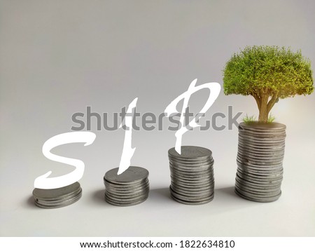 Systematic investment plan concept by increasing coins stack to an aim,