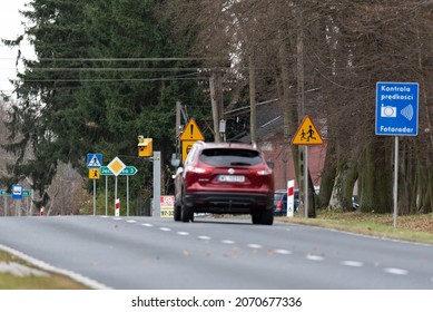Szadki, Poland - November 5, 2021: Speed camera at the pedestrian crossing in front of the intersection. Information signs about speed measurement in built-up areas. Safety on the road.