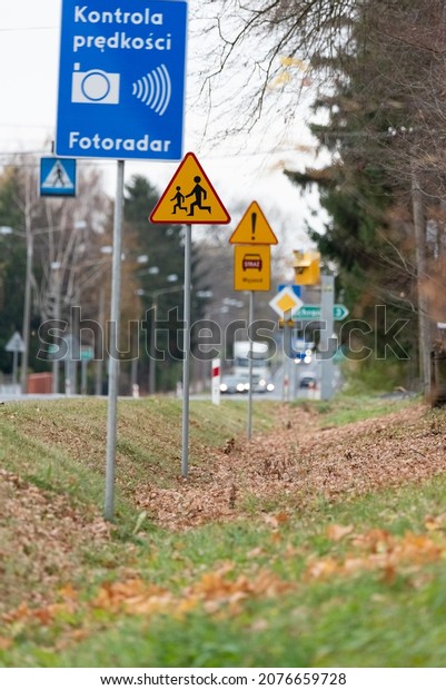 Szadki, Poland - November 5, 2021: Speed camera at\
the pedestrian crossing in front of the intersection. Information\
signs about speed measurement in built-up areas. Safety on the\
road.