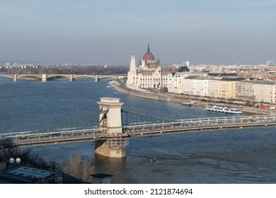 Szechenyi chain bridge across Danube river under renovation and parliament building in Budapest, Hungary