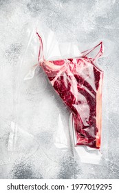 T Bone Or Porterhouse Dry Aged  Steak In Vacuum Pack  Set, On Gray Stone Background, Top View Flat Lay