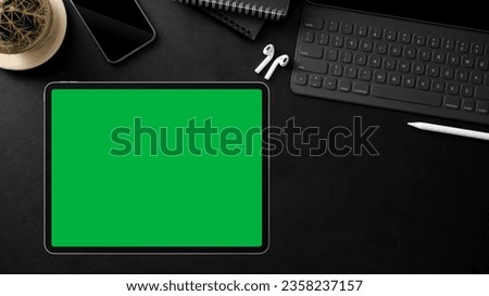 A tab and green screen on a table