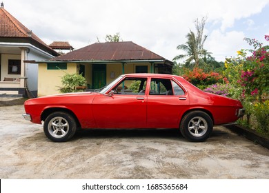 Tabanan, Bali / Indonesia - 29 February 2020: A Classic Red Muscle Car With Double White Strips, Named Holden Kingswood. Left Side.