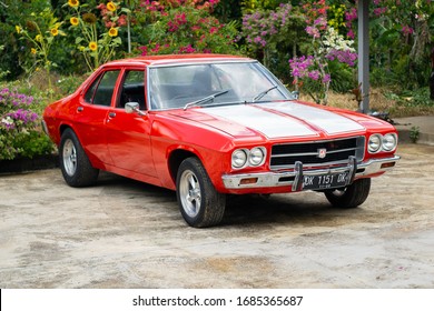 Tabanan, Bali / Indonesia - 29 February 2020: A Classic Red Muscle Car With Double White Strips, Named Holden Kingswood.