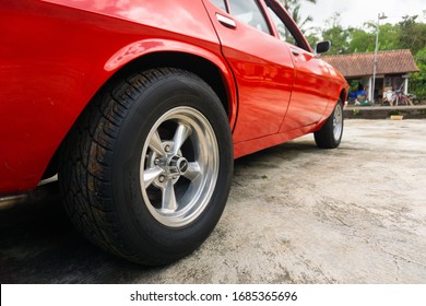 Tabanan, Bali / Indonesia - 29 February 2020: A Classic Red Muscle Car With Double White Strips, Named Holden Kingswood. Corner Back View.