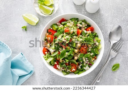 Tabbouleh salad. Tabouli salad with fresh parsley, onions, tomatoes, bulgur and chickpea. Healthy vegetarian food, mediterranean diet. Top view