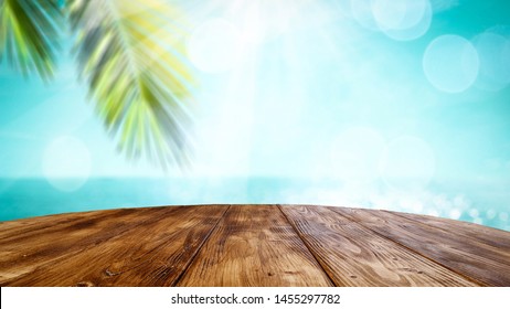 Table Background And Beautiful Sunny Beach And Ocean View In Distance. Empty Space On The Table Top For An Advertising Product.