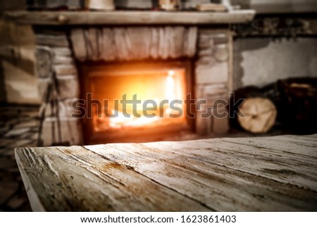 Table background of free space and blurred fireplace in home interior 