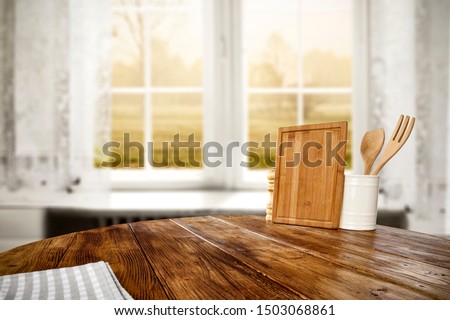 Table background of free space for your decoration and blurred background of window with autumn landscape 
