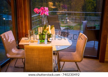 A table in the background of a panoramic window. Vacation home. Cottage.