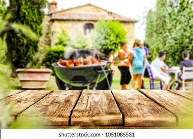 Table background and space for your decoration with blurred background with grill party and some people. 