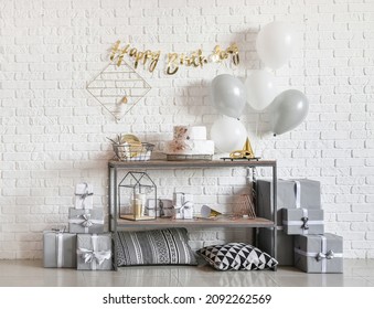 Table With Birthday Cake And Balloons Near Brick Wall