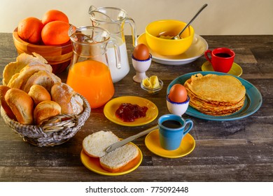 table of breakfast full set with eggs, pancakes, bread, jam ,juice and more