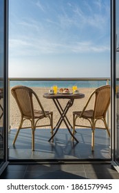 Table With Breakfast And Two Chairs On A Hotel Balcony By The Beach
