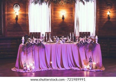 Table for bride and groom with decor, flowers, candles and dishes