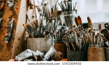 Table with brushes and tools in an art workshop. Background.