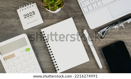 Table calendar. To-do list and plans for 2023 Goals for next year, Agenda, planner book, laptop, pen on office desk. Diary for organizer to plan timetable, daily appointment and and Calendar Concept.