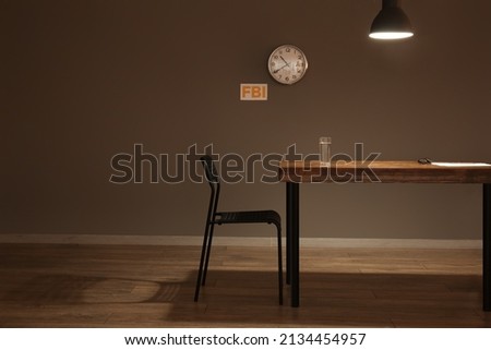 Table and chair in empty interrogation room