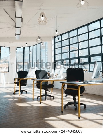 Table, chair and empty office interior with room, window and workspace with design, computer and tech. Furniture, pc and company with desk, monitor and workplace at startup creative agency in Italy
