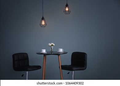 Table With Chairs Against Dark Wall. Elegant Interior