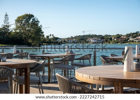 Table and chairs from a beach bar restaurant near a lake in Ria Formosa region, located in Quinta do Lago, Portugal.