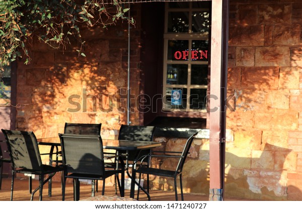 Table Chairs Contrasted Against Sunlit Stone Stock Image