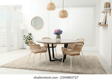 Table, chairs and vase of hydrangea flowers in dining room. Stylish interior - Powered by Shutterstock