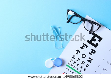 a table for checking vision, glasses and lenses for correcting vision on a colored background, top view. Ophthalmologist Accessories.
