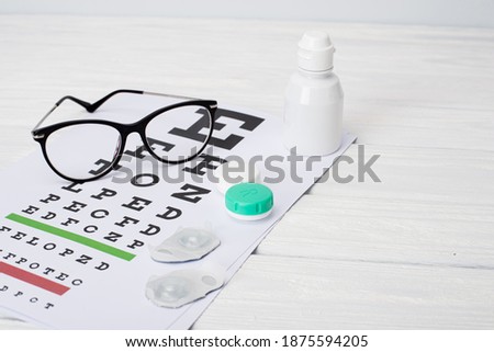 a table for checking vision, glasses and lenses for correcting vision on a colored background, top view. Ophthalmologist Accessories.