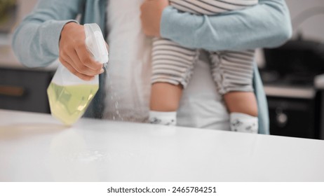 Table, cleaning and hand of person with spray for housekeeping, hygiene or maintenance on weekend. Kitchen, baby and housewife with chemical at home for safety, surface or removal of bacteria - Powered by Shutterstock