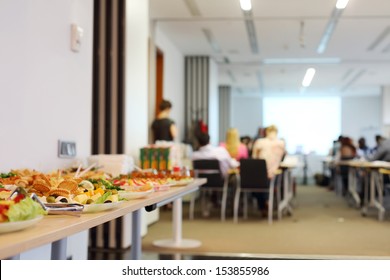 Table with cold snacks and refreshments for business meeting. Focus on food.