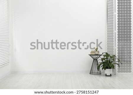 Table with decor and folding screen indoors. Interior design